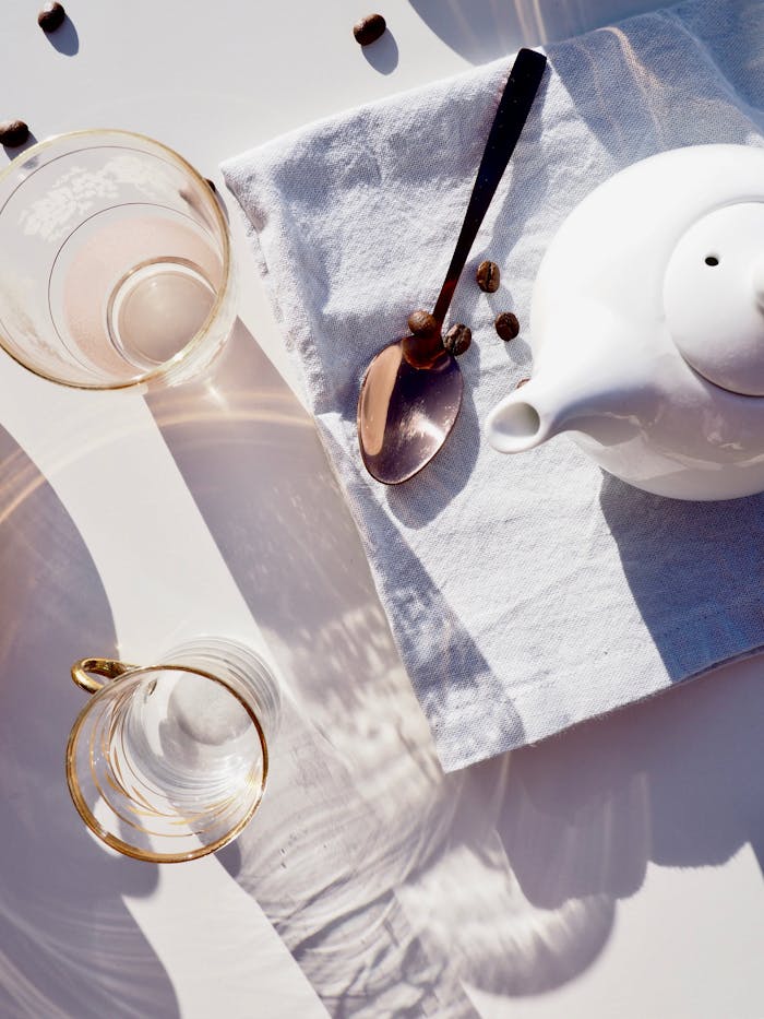 Whit Ceramic Teapot on Towel Near Spoon